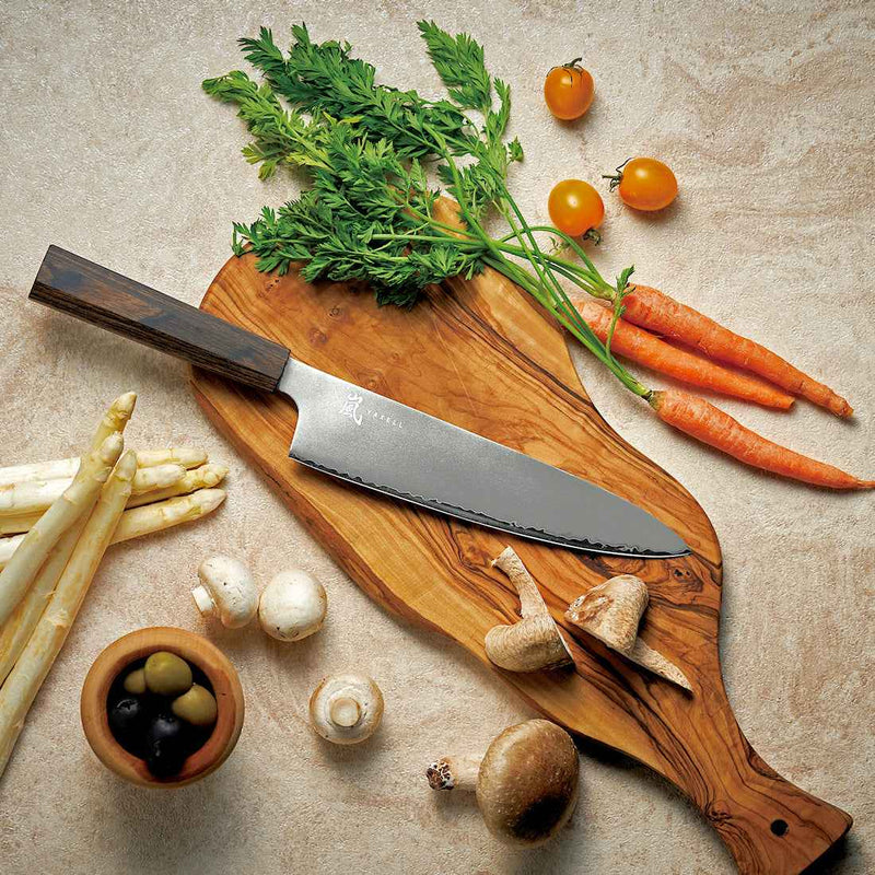 Alt-teksti (suomeksi):  
Yaxell Hana japanilainen keittiöveitsi puualustalla vihannesten kanssa.