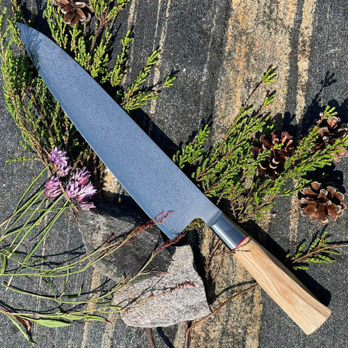 Alt-teksti: Japanilainen keittiöveitsi puukahvalla luonnon keskellä