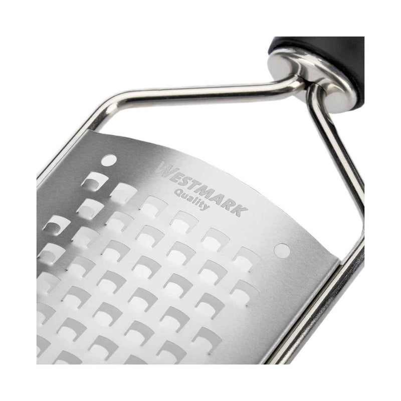 Lähikuva Westmark mikroteräraastimen terästä ja logosta. Laadukas keskikarkea raastin keittiötarvikkeisiin.