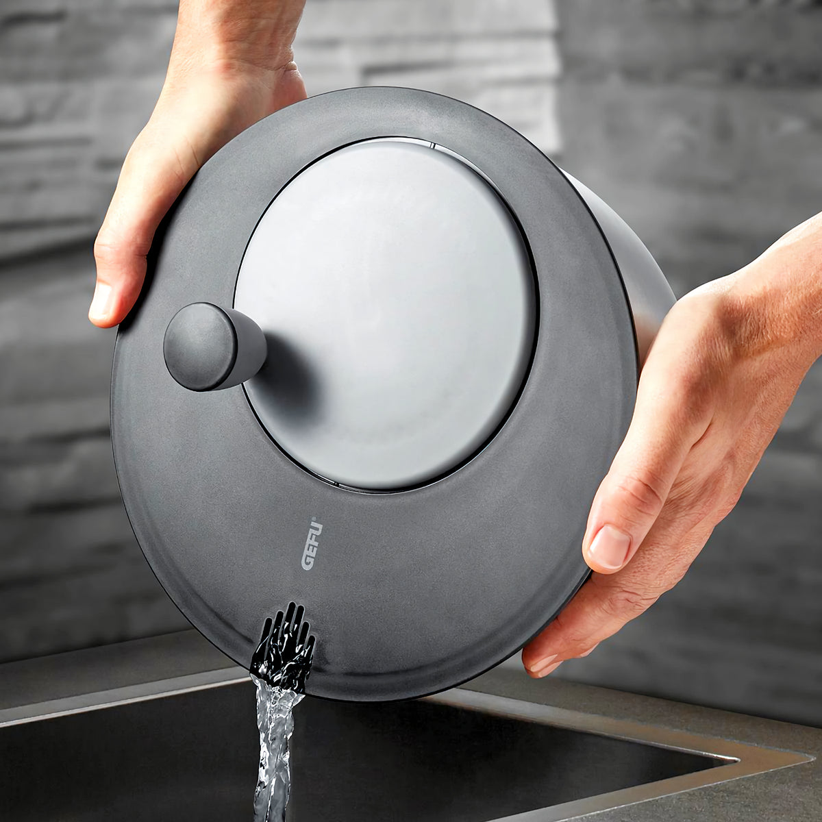 Gefu Rotare salaattilingon kansi kallistettuna veden poistamiseksi. Innovatiivinen ja käytännöllinen ratkaisu salaatin huuhteluun.