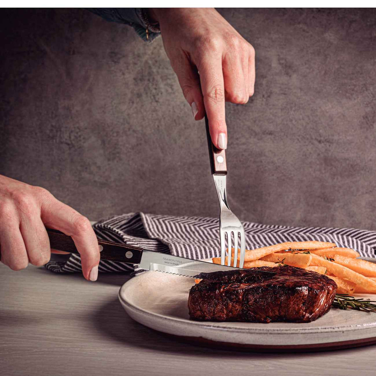 Pihviaterimet leikkaamassa pihviä lautasella