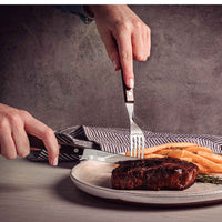 Pihviaterimet leikkaamassa pihviä lautasella