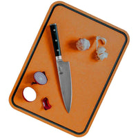 Dorre Sami leikkuulauta käytössä, veitsi ja vihanneksia laudan päällä. Kestävä ja monikäyttöinen keittiövaruste.