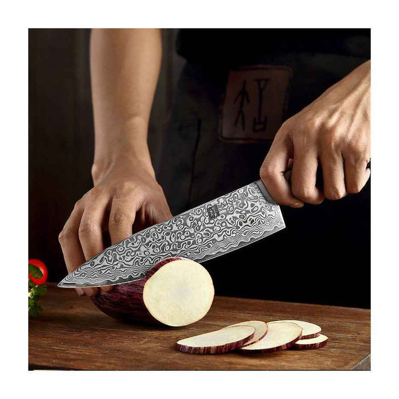 Xinzuo Ya Damascus keittiöveitsi käytössä munakoison viipaloinnissa, osoittaen terän leikkuuvoiman ja ergonomisen otteen.