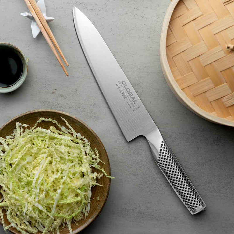 Global Classic G-2 kokkiveitsi 20 cm ja kaalisalaatti – kuvassa veitsi ja silputtu kaali leikkuulaudalla