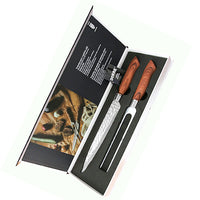 Avoin Dorre paistiveitsien ja haarukan lahjapakkaus, sisältäen tyylikkäästi esille asetetut keittiövälineet ja tuotetiedot.