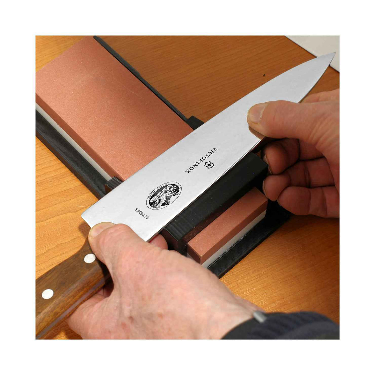 Veitsen teroitus kulmaohjaimella teroituskivellä, tarkka 15 tai 20 asteen kulma, keittiövaruste veitsien huoltoon kotikäytössä.