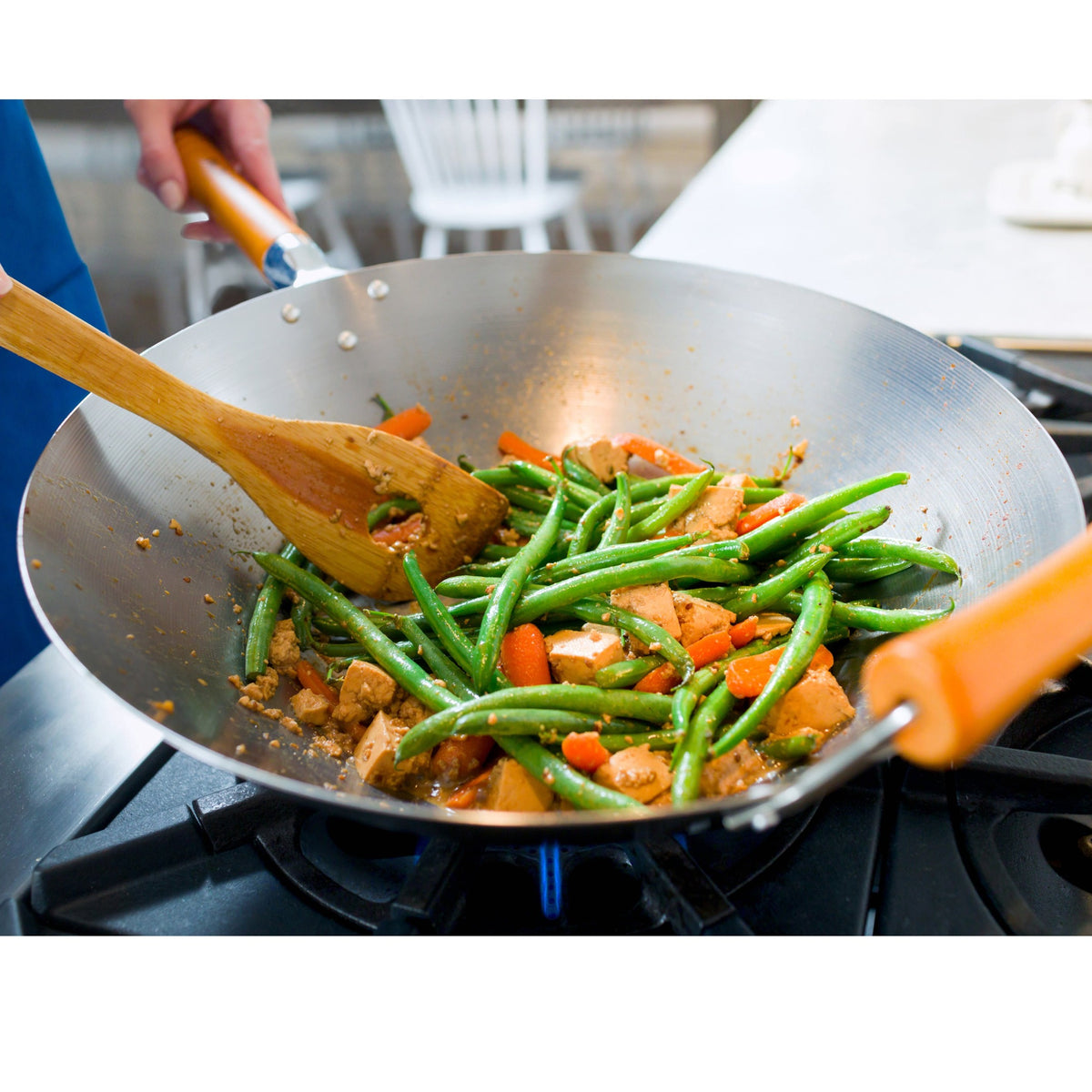Ken Hom Hiiliteräswok liedellä, sisältäen vihanneksia ja puulastan. Kestävä ja monikäyttöinen wokpannu.