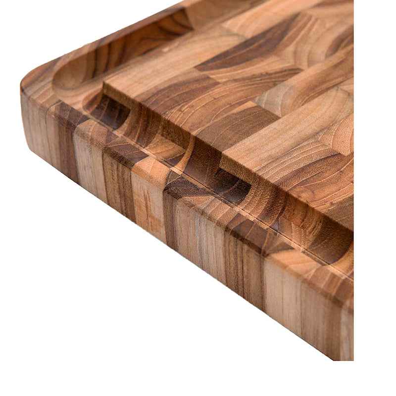 Lähikuva Leikkuulauta Teak Butcher's Block -leikkuualueesta ja nesteurasta, korostaen tiikkipuun kestävyyttä ja viimeistelyä.