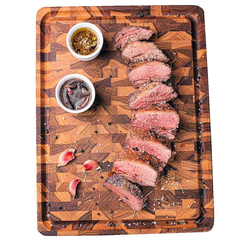 Viipaloitu naudanliha tarjoiltuna Leikkuulauta Teak Butcher's Block -laudalla, nesteura estää valumisen pöydälle.