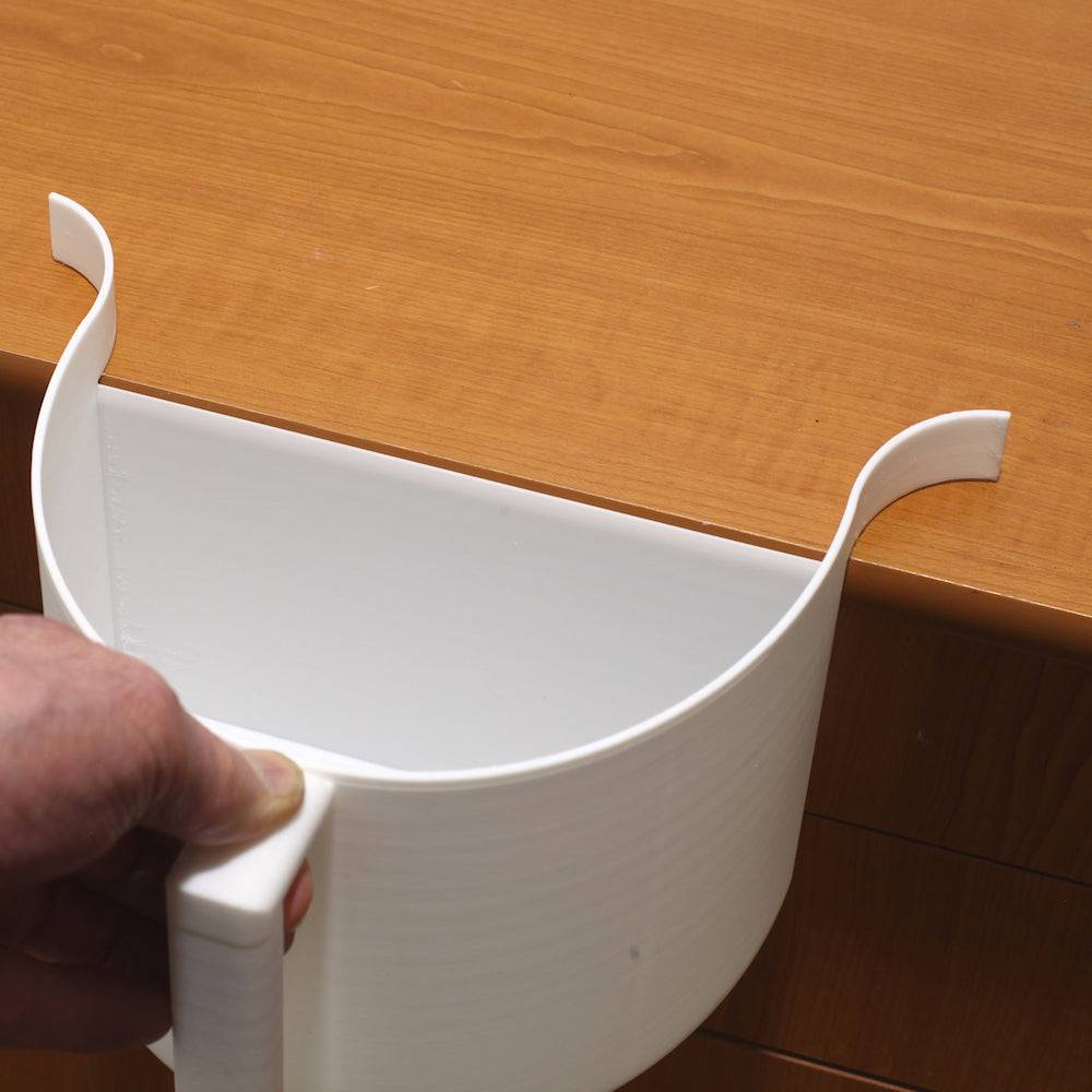 Pöytäroska-astia Puhdas Keittiö asetettuna pöydän reunaan, käytännöllinen muotoilu mahdollistaa nopean tyhjennyksen ja siistin keittiön.