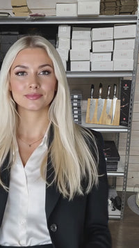 Esittelijä seisoo Xinzuo-veitsisarjan edessä, taustalla veitsiteline ja pakkauksia, premium-keittiövälineet esillä