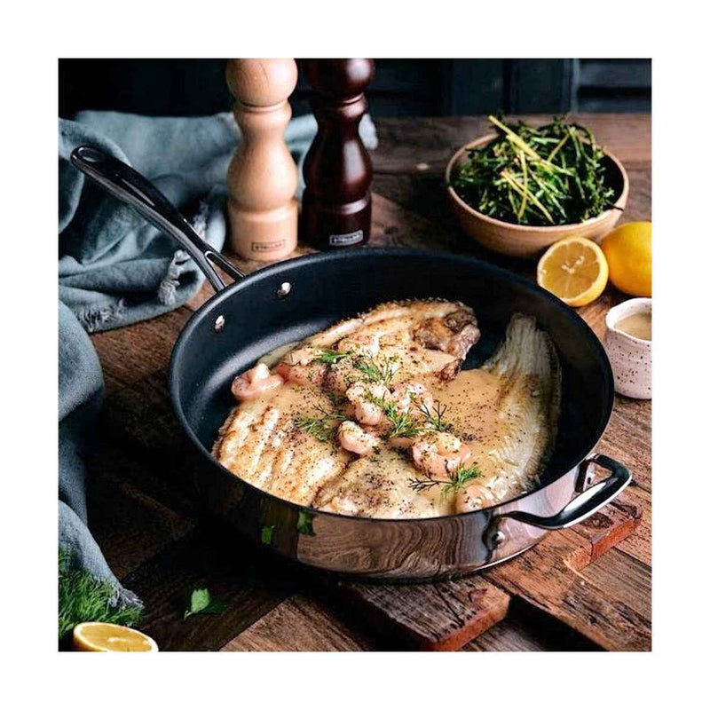 Stellar pinnoitettu paistokasari 28 cm käytössä, paistettu kala ja yrtit pannulla. Laadukas keittiöväline ruoanlaittoon kotikokeille.