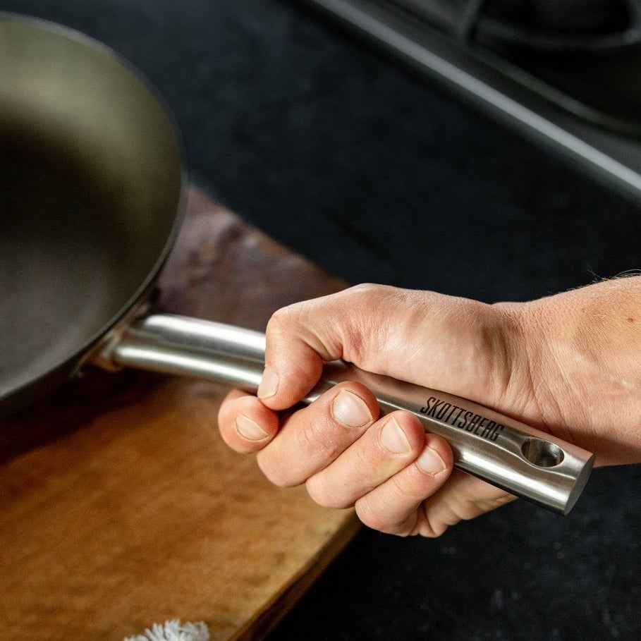Skottsberg Paistinpannu 20 cm käytössä, ergonominen teräskahva tarjoaa tukevan otteen ruoanlaitossa keittiössä tai ulkona.