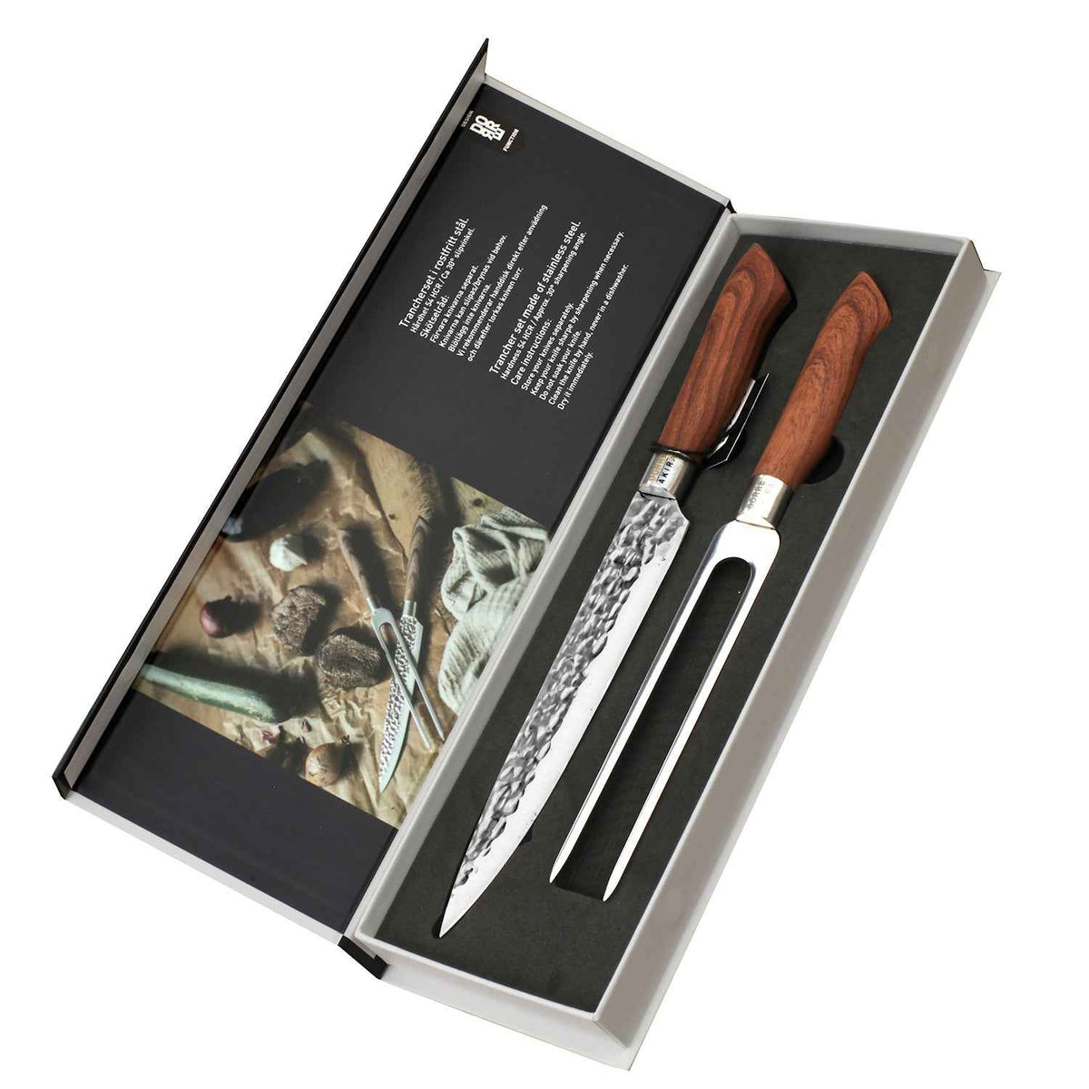 Avoin Dorre paistiveitsien ja haarukan lahjapakkaus, sisältäen tyylikkäästi esille asetetut keittiövälineet ja tuotetiedot.