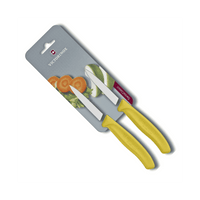 Victorinox Kuorimaveitsi Setti - 8 cm, 2 kpl Swiss Classic keltaisella kahvalla, pakkauksessa vihanneksia taustalla. Täydellinen juuresten kuorintaan.