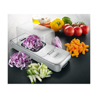 Alligator De Luxe vihannesleikkuri ruostumaton teräs pilkkoo sipulin, kurkun ja paprikan kuutioiksi ja suikaleiksi keittiötasolla.