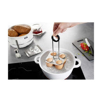 Gefu Brunch kananmunan keittoteline asetetaan kiehuvaan veteen. Kätevä kahva helpottaa käyttöä ja turvallista käsittelyä.