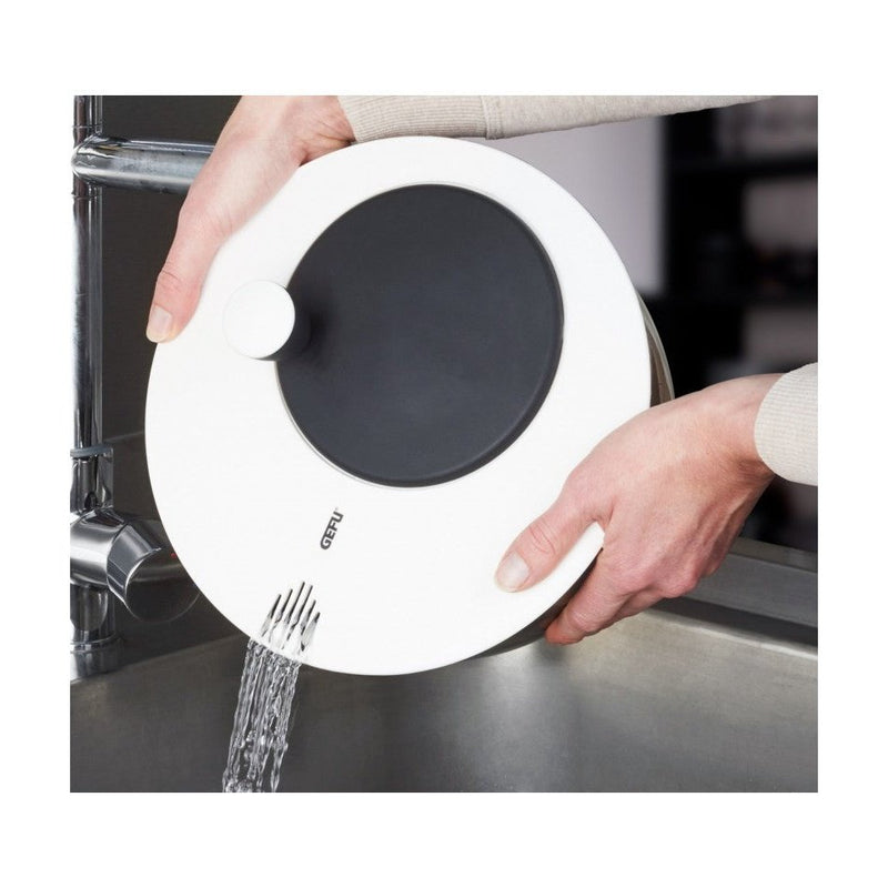 Gefu salaattilinko kammella valuttamassa vettä altaaseen. Kätevä vedenpoistoaukko helpottaa käyttöä ja puhdistusta.