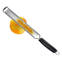 Westmark mikroteräraastin 40 cm käytössä appelsiinin kuoren raastamiseen, tarkka ja tehokas keittiöväline sitrushedelmille ja juustoille.