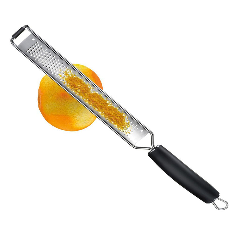 Westmark mikroteräraastin 40 cm käytössä appelsiinin kuoren raastamiseen, tarkka ja tehokas keittiöväline sitrushedelmille ja juustoille.