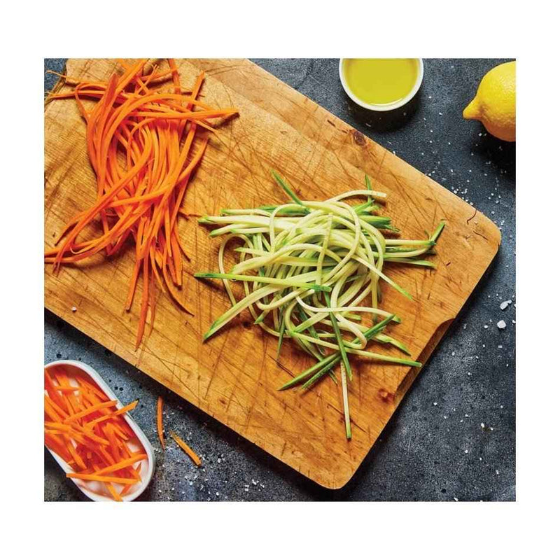 Porkkana- ja kesäkurpitsasuikaleita leikkuulaudalla, valmistettu Börner V3 Mandoliinilla.