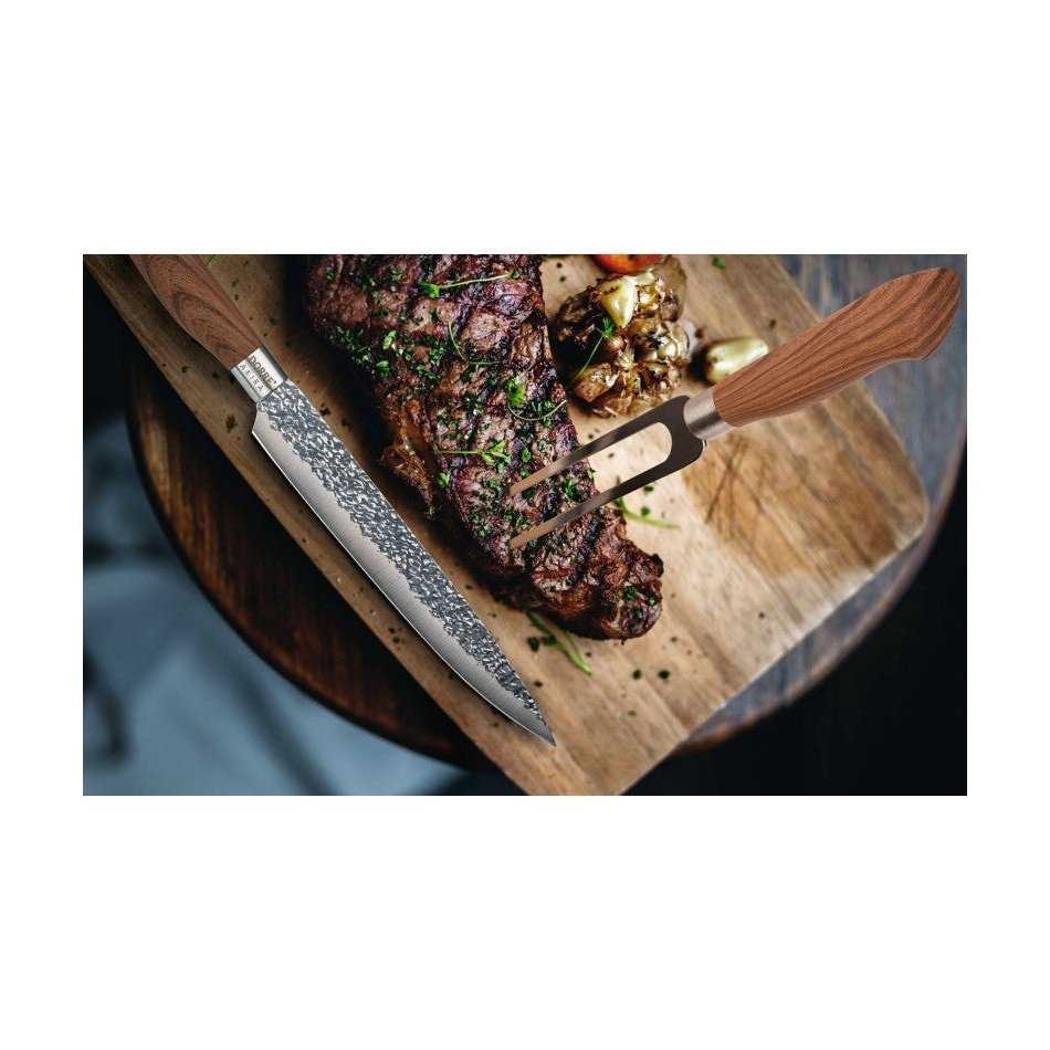 Dorre Paistihaarukka Veitsisetti - 3 osaa käytössä, veitsi ja haarukka leikkaavat mehukasta pihviä puulevyn päällä, korostaen terävyyttä ja laatua.