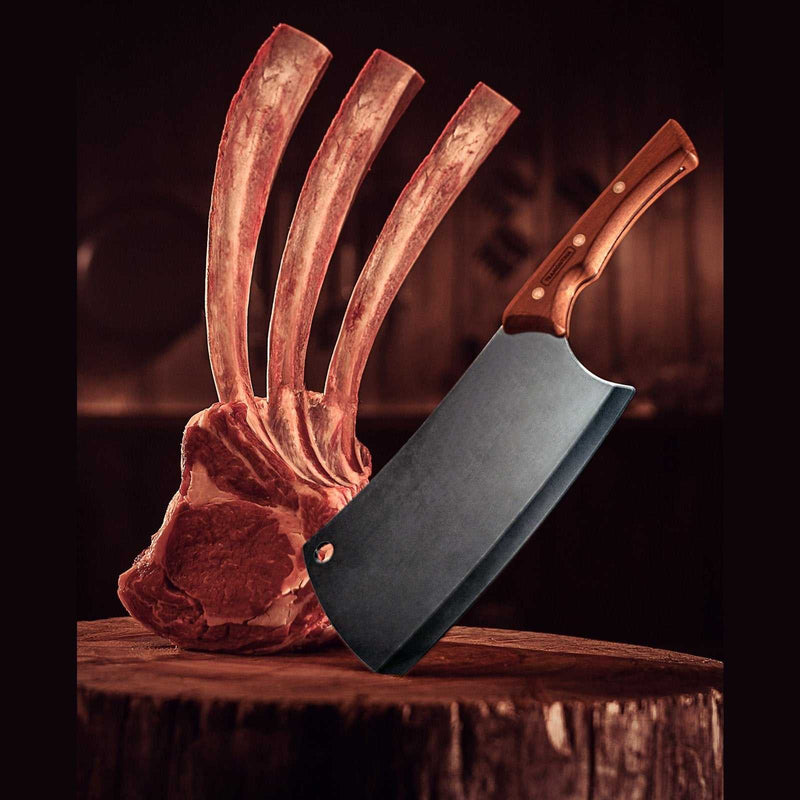 Tramontina Black Lihakirves, 18 cm, puukahva ja tummaksi oksidoitu terä. Kuvassa lihakirves ja suuri lihapala, täydellinen luiden katkaisuun.